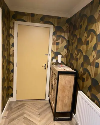 Hallway hung with a blue and gold patterned wallpaper